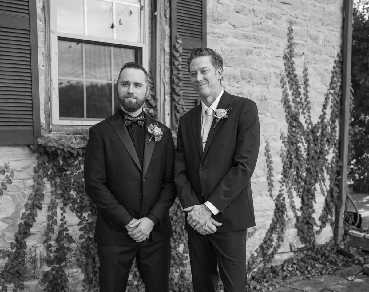 Co-founders Jon Bruhin and Caleb Rabadan in suits at a wedding